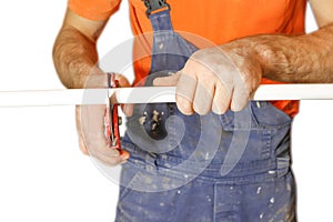 Man worker cuts off a piece of polypropylene pipes. Isolated on