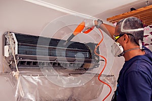 Man worker doing cleaning of air conditioning