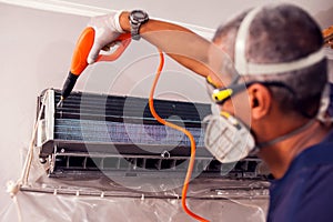 Man worker doing cleaning of air conditioning