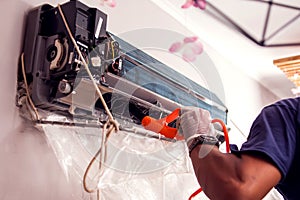 Man worker doing cleaning of air conditioning