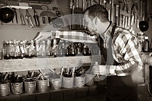 Man worker examining colorants for leather in leather workshop photo