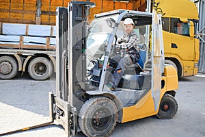 Man worker at forklift driver happy working in industry factory logistic ship