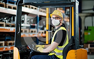 Man worker forklift driver with protective mask working in industrial factory or warehouse.