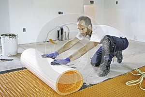 Man worker install orange roll membrane waterproofing on the floor