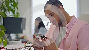 Man Worker Looking at Motherboard. It Company. Guy Master Checks the Electronic Board and Performs Electrical