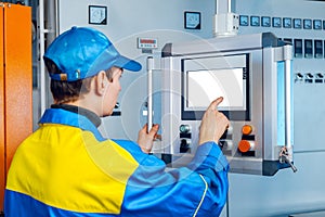 Man worker in manufacturing plant at cable factory machine control computer panel