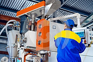 Man worker in manufacturing plant at cable factory machine control computer panel