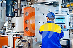 Man worker in manufacturing plant at cable factory machine control computer panel