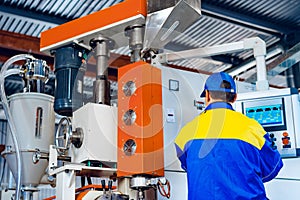 Man worker in manufacturing plant at cable factory machine control computer panel