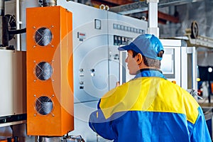 Man worker in manufacturing plant at cable factory machine control computer panel
