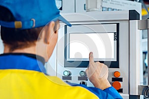 Man worker in manufacturing plant at cable factory machine control computer panel