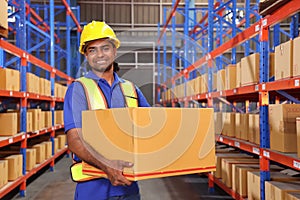 A man worker packing cardboard box with tape gun dispenser in warehouse