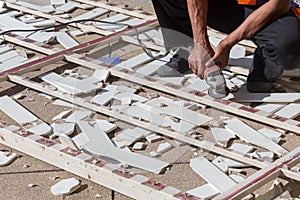 Man worker repairing steel fence with electric saw