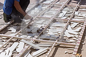 Man worker repairing steel fence with electric saw