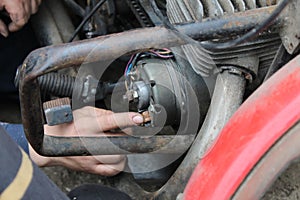 Man worker repairs motorcycle carburetor