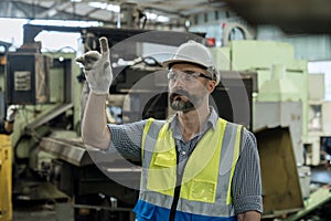 Man worker in safety helmet working on steel machine. Worker miller operating milling machine at industrial manufacturing factory