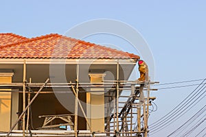 Man worker on scaffold painting roof