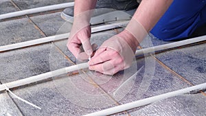 man worker takes measurements during the installation of a warm floor