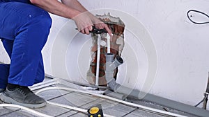 man worker takes measurements during the installation of a warm floor