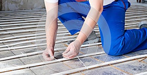 man worker takes measurements during the installation of a warm floor