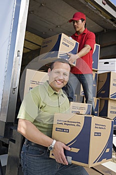 Man With Worker Unloading Truck Of Cardboard Boxes