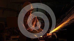 The man worker uses grinding cutting machine to cut metal