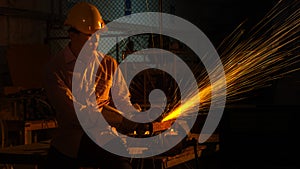 The man worker uses grinding cutting machine to cut metal