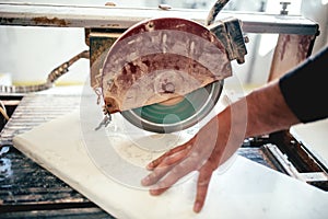 man, worker using circular saw for cutting slate and marble