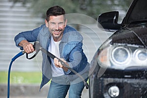 man worker washing car on car wash