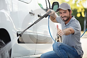 man worker washing car on car wash