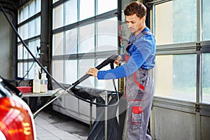 Man worker washing car on a car wash