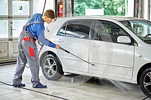 Man worker washing car on a car wash