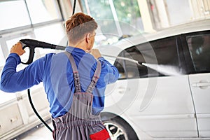 Man worker washing car on a car wash