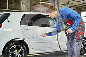 Man worker washing car on a car wash