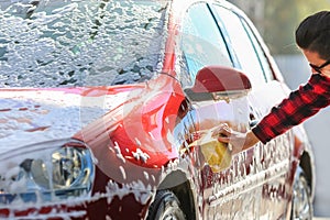 Man worker washing car`s alloy wheels on a car wash