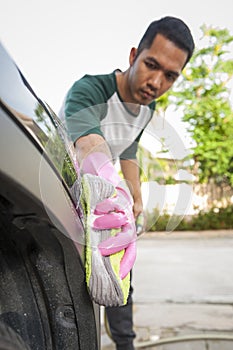 Man worker washing car`s on a car wash. Cleaning concept.