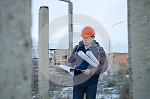 The man worker wear a orange helmet with construction site