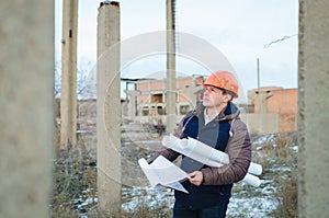 The man worker wear a orange helmet with construction site