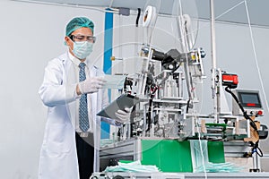 Man worker wear uniform are checking quality medical mask of manufacturer factory. face mask industry factory.