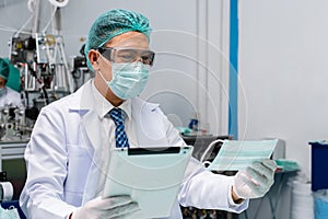 Man worker wear uniform are checking quality medical mask of manufacturer factory. face mask industry factory. manufacturer