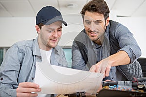 man working with apprentice in printing house