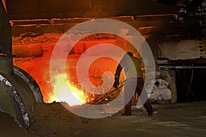 Man working on blast furnace.