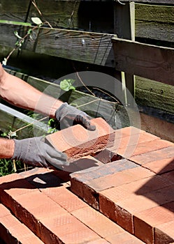 Man working with bricks. Construction works in process. Close up photo of red bricks.