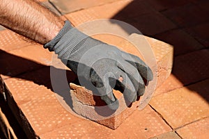 Man working with bricks. Construction works in process. Close up photo of red bricks.