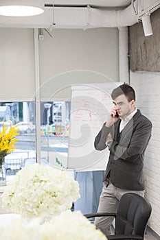 Man working in a bright modern office with a laptop in a business suit