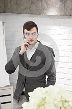 Man working in a bright modern office with a laptop in a business suit