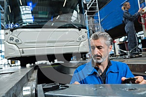 man working in bus garage