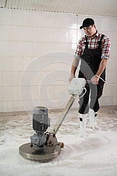 Man working on Carpet chemical cleaning with professionally disk machine. Regular clean-up. photo