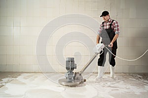 Man working on Carpet chemical cleaning with professionally disk machine. photo