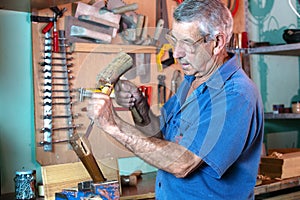 Man working carving wood with a chisel and hammer
